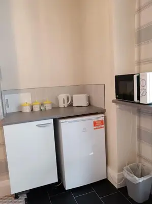a small kitchen with a white refrigerator and a microwave at Sea View in Heysham