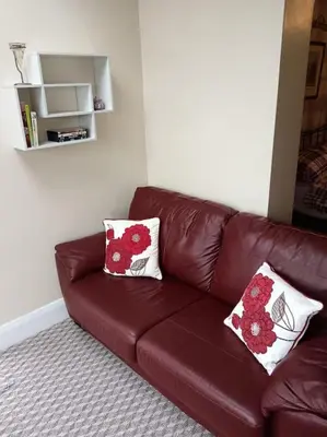 a brown leather couch in a room with two pillows at Sea View in Heysham