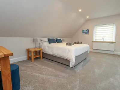 a bedroom with a large bed and a window at Treetops in Newton
