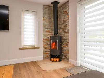 a fireplace in a room with a brick wall at Treetops in Newton