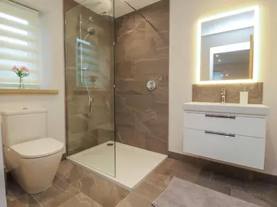 a bathroom with a shower and a toilet and a sink at Treetops in Newton