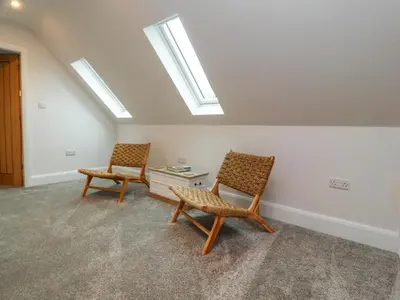 two chairs and a table in a room with skylights at Treetops in Newton