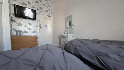a bedroom with a bed and a flat screen tv at Martell's Hotel in Blackpool