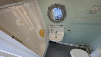 a bathroom with a sink and a toilet and a mirror at Martell's Hotel in Blackpool