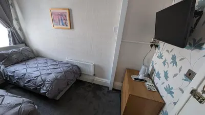 a small room with a bed and a flat screen tv at Martell's Hotel in Blackpool