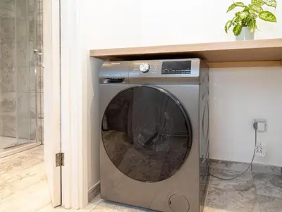 a washer and dryer in a room at Comfy 5 star Stays - 6 Bedrooms - Sleeps 8 - Free Parking & WiFi - Wirral in New Brighton