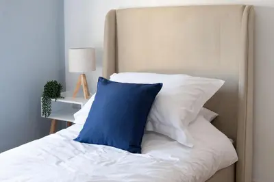 a bed with a blue pillow on top of it at Red & Blue flat 15mins to Liverpool city centre, free parking in New Brighton