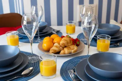 a table with plates of food and glasses of orange juice at Red & Blue flat 15mins to Liverpool city centre, free parking in New Brighton