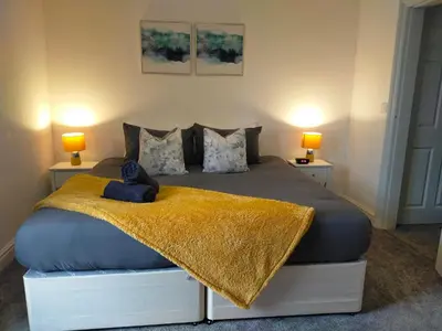 a bedroom with a bed with a teddy bear on a blanket at Newly Renovated 3 Bedroom House, 6 beds with 2 showers, near University Town Centre in Lancaster