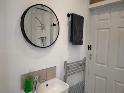 a bathroom with a sink and a mirror on the wall at Newly Renovated 3 Bedroom House, 6 beds with 2 showers, near University Town Centre in Lancaster