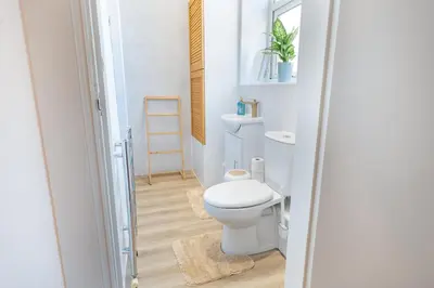 a bathroom with a white toilet in a room at Terracotta Apartment, free WiFi & parking, coastal location in New Brighton