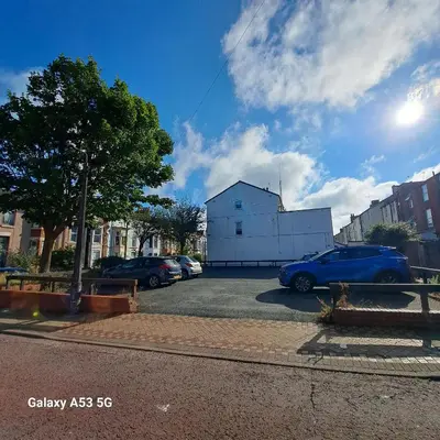 a parking lot with cars parked in front of a building at Terracotta Apartment, free WiFi & parking, coastal location in New Brighton