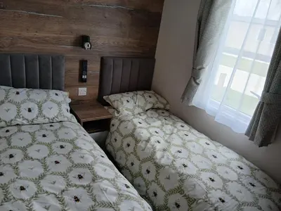a bedroom with a bed and a window at 3-Bed Caravan - Haven Lakeland Leisure Park in Grange Over Sands
