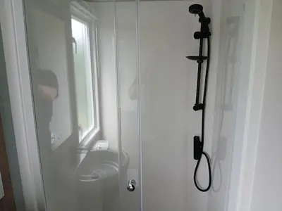 a white bathroom with a sink and a window at 3-Bed Caravan - Haven Lakeland Leisure Park in Grange Over Sands