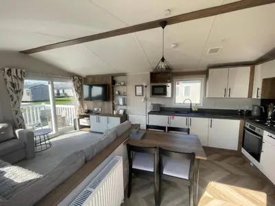 a kitchen and living room with a couch and a table at 3-Bed Caravan - Haven Lakeland Leisure Park in Grange Over Sands