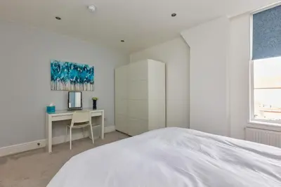 a white bedroom with a desk and a bed at Lytham St Annes Luxury Apartment - No 2 Tides Reach in Lytham St Annes