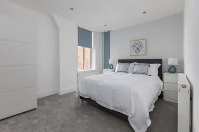 a white bedroom with a bed and a window at Lytham St Annes Luxury Apartment - No 2 Tides Reach in Lytham St Annes