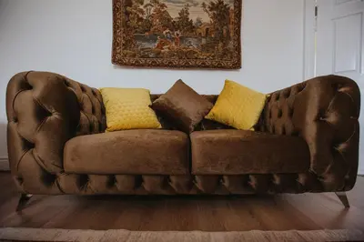 a brown couch with two yellow pillows on it at Grand Victorian Villa 6 - En-Suites, Hot Tub, Cinema Room, Private Parking & Park View in Liverpool