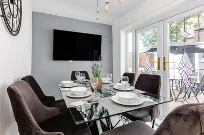 a dining room with a glass table and chairs at Grand Victorian Villa 6 - En-Suites, Hot Tub, Cinema Room, Private Parking & Park View in Liverpool
