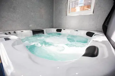 a jacuzzi tub with blue water in it at Grand Victorian Villa 6 - En-Suites, Hot Tub, Cinema Room, Private Parking & Park View in Liverpool