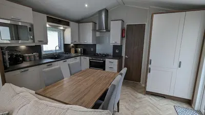 a kitchen with a wooden table in a room at Lake View - Beacon Fell View Holiday Park in Longridge