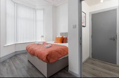 a bedroom with a bed with orange pillows on it at Residency apartments Liverpool in Liverpool
