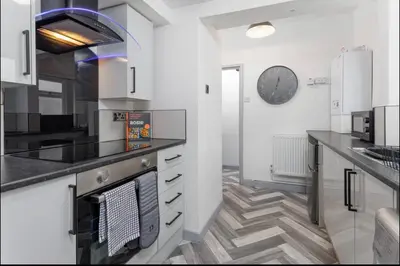 a kitchen with white cabinets and a stove top oven at Residency apartments Liverpool in Liverpool
