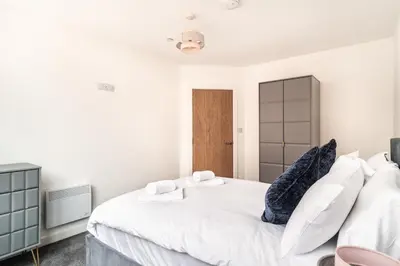 a bedroom with a large white bed with blue pillows at Lovely 1 Bed Central Preston Apartment in Preston