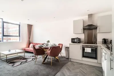 a kitchen and living room with a table and a couch at Lovely 1 Bed Central Preston Apartment in Preston
