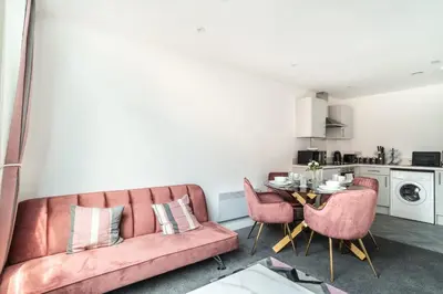 a living room with a pink couch and a table at Lovely 1 Bed Central Preston Apartment in Preston