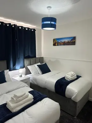 a bedroom with two beds and a blue light at Affluent Living Property perfect for contractors and individuals in Wigan