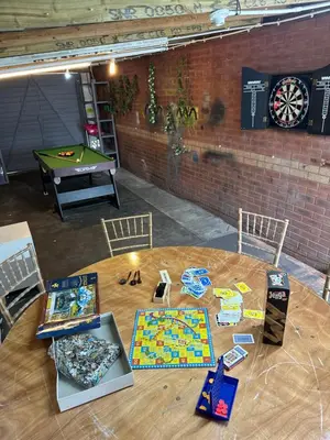 a table with games and a dart board on it at Affluent Living Property perfect for contractors and individuals in Wigan
