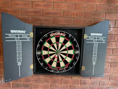 a dart board mounted on a brick wall at Affluent Living Property perfect for contractors and individuals in Wigan