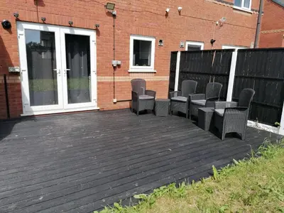 a deck with chairs on it in front of a building at Affluent Living Property perfect for contractors and individuals in Wigan