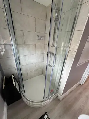 a shower with a glass door in a bathroom at Entire House at Buckingham Road in Morecambe