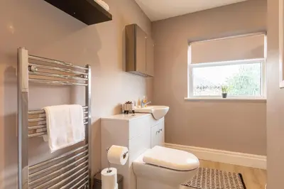 a bathroom with a toilet and a sink and a window at Entire House at Buckingham Road in Morecambe