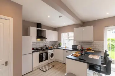 a kitchen with white cabinets and a counter top at Entire House at Buckingham Road in Morecambe