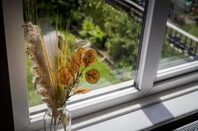 a glass vase with dried flowers in a window at Entire House at Buckingham Road in Morecambe