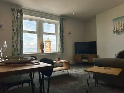 a living room with a large window and a tv at Clock Tower Apartment No4 in Morecambe