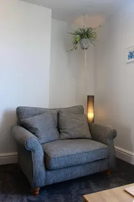 a couch in a living room with a plant on the ceiling at Clock Tower Apartment No4 in Morecambe