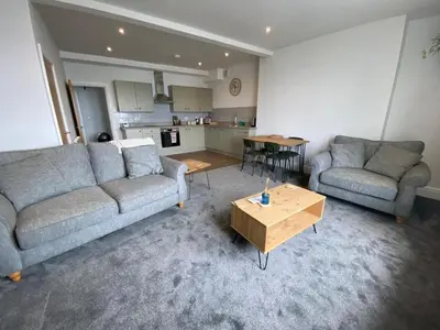 a living room with two couches and a table at Clock Tower Apartment No4 in Morecambe