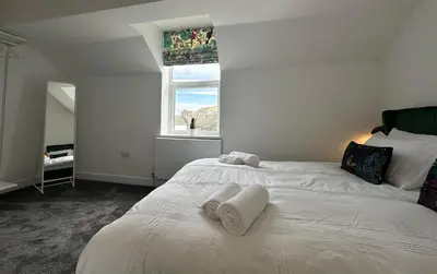 a bedroom with a white bed with towels on it at Clock Tower Apartment No4 in Morecambe
