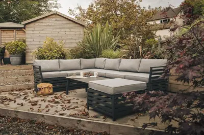 a garden with a couch and a coffee table at Coronation Family Cottage, Modernised 200-Year-Old Lake District Cottage with Private Hot Tub and Parking - Ridgestone in Lindale
