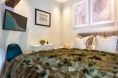 a bedroom with a large bed with a blanket at Coronation Family Cottage, Modernised 200-Year-Old Lake District Cottage with Private Hot Tub and Parking - Ridgestone in Lindale