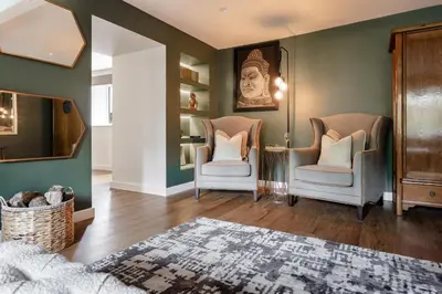 a living room with two chairs and a mirror at Coronation Family Cottage, Modernised 200-Year-Old Lake District Cottage with Private Hot Tub and Parking - Ridgestone in Lindale