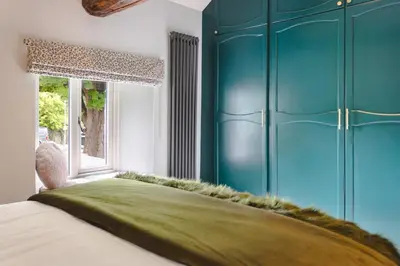 a bedroom with a bed with a blue cabinet at Coronation Family Cottage, Modernised 200-Year-Old Lake District Cottage with Private Hot Tub and Parking - Ridgestone in Lindale
