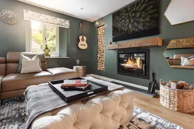 a living room with a couch and a fireplace at Coronation Family Cottage, Modernised 200-Year-Old Lake District Cottage with Private Hot Tub and Parking - Ridgestone in Lindale