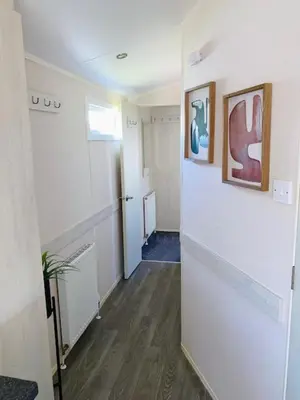 a room with a hallway with white walls and wood floors at Haven, Cala Gran caravan park, privately owned in Blackpool