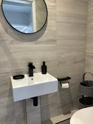 a bathroom with a white sink and a mirror at Goldie's Retreat in Blackrod