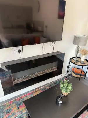 a living room with a fireplace with a mirror at Goldie's Retreat in Blackrod